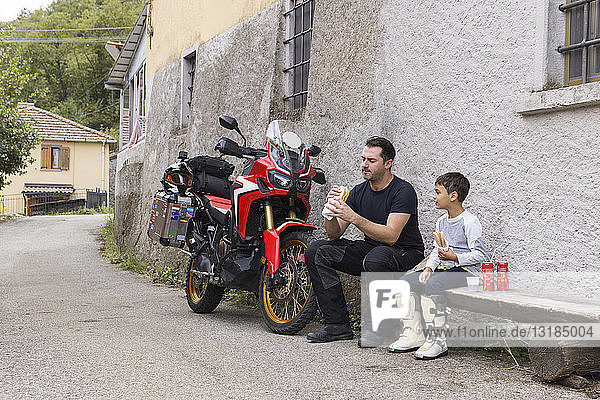 Vater und Sohn machen während einer Motorradtour eine Mittagspause