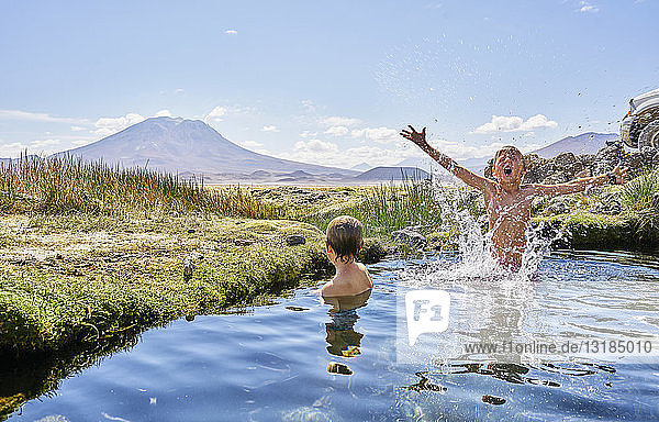 Chile Salar del Carmen zwei Jungen baden in einer heißen Quelle