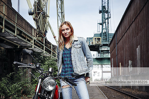 Porträt einer selbstbewussten jungen Frau mit Motorrad