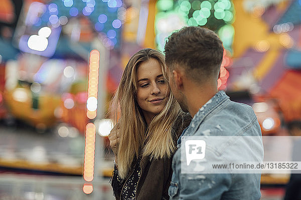 Junges verliebtes Paar  das sich auf einem Jahrmarkt umarmt