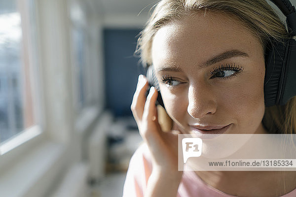 Lächelnde junge Frau  die zu Hause Musik hört