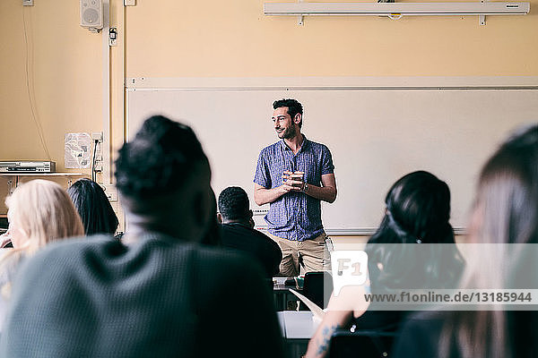 Männlicher Lehrer unterrichtet multiethnische Studenten im Klassenzimmer