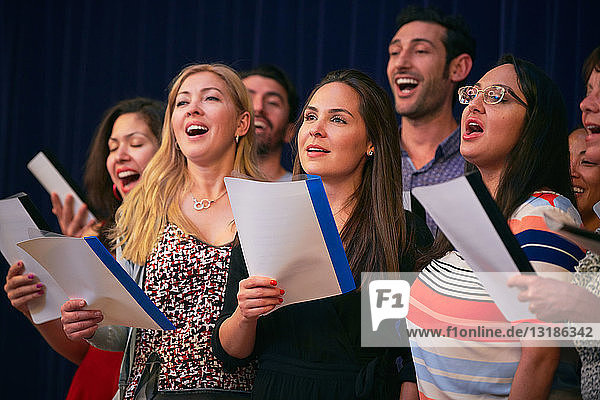Multi-ethnische Freunde singen bei Chorprobe in Sprachschule