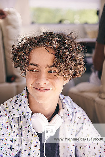 Nahaufnahme eines nachdenklich lächelnden Mannes mit Kopfhörern  der im Lieferwagen wegschaut