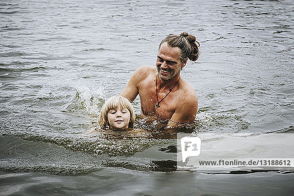 Vater und Sohn schwimmen im See