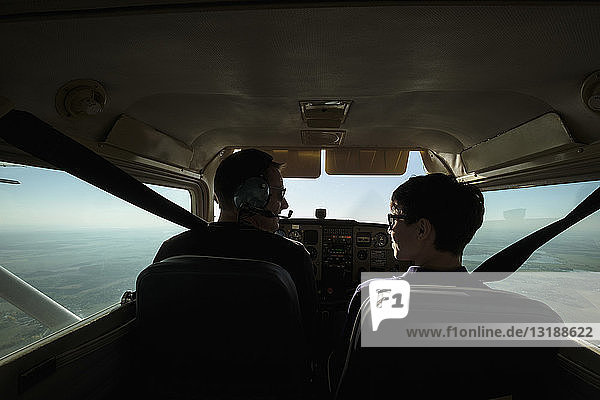 Father and son flying in small airplane