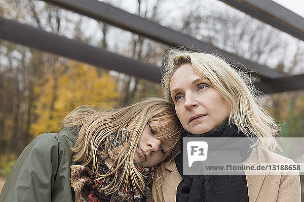 Liebevolle  heitere Mutter und Tochter im Herbstpark