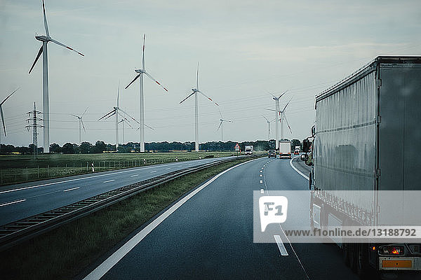 Lastwagen und Autos fahren auf der Autobahn entlang von Windkraftanlagen  Brandenburg  Deutschland