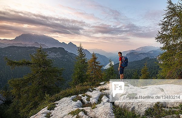 Hiker at the summit of Feldkogel  mountain landscape  view of KÃ¶nigssee at sunset  left Watzmann SÃ¼dspitze and Watzmannkinder  Berchtesgaden National Park  Berchtesgadener Land  Upper Bavaria  Bavaria  Germany  Europe
