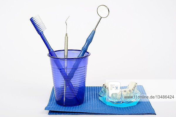 Zahnpflege  Zahnbürste  Zahnspiegel  zahnärztliche Instrumente und Zähne mit fester Zahnspange