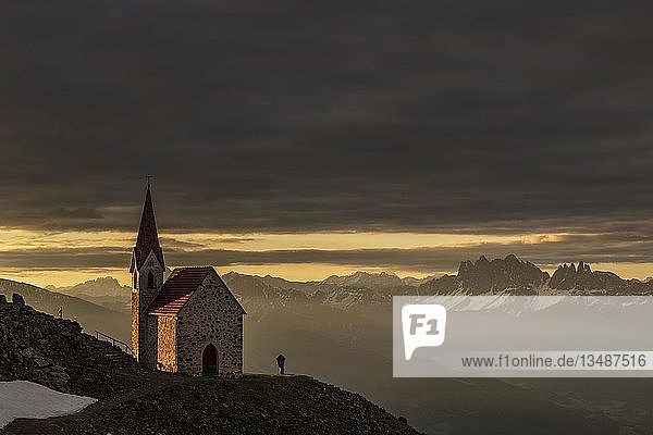 Latzfonser Kreuzkapelle bei Sonnenaufgang mit dramatischen Wolken und Südtiroler Bergen  Sarntaler Alpen  San Martino  Sarntal  Südtirol  Italien  Europa