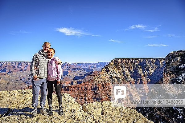 Paar umarmt sich vor der gigantischen Schlucht des Grand Canyon  Blick vom Rim Trail  zwischen Mather Point und Yavapai Point  erodierte Felslandschaft  South Rim  Grand Canyon National Park  bei Tusayan  Arizona  USA  Nordamerika