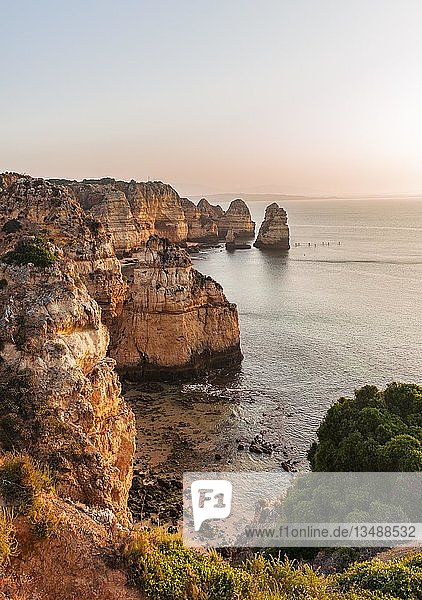 Sonnenaufgang über dem Meer  felsige Küste aus Sandstein  Felsformationen im Meer  Algarve  Lagos  Portugal  Europa