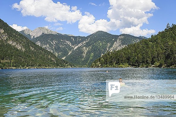 Young man bathing  swimming in Lake Plansee  turquoise water  mountain lake  mountain landscape  Tyrolean Alps  Reutte  Tyrol  Austria  Europe