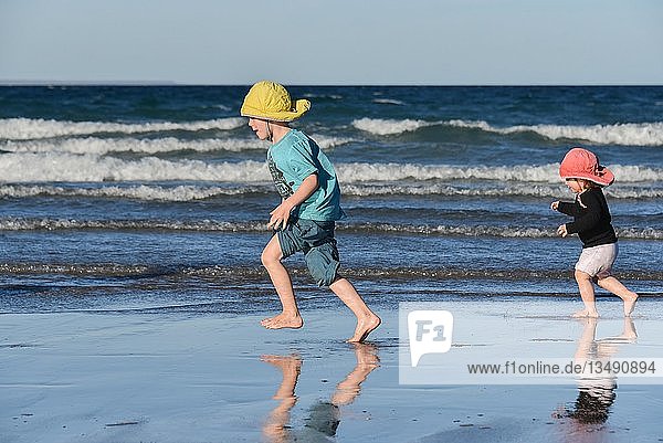 Junge und Mädchen laufen am Strand  Puerto Madryn  Argentinien  Südamerika