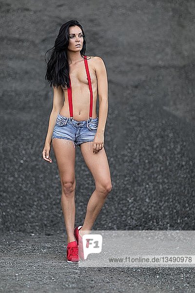 Woman with jeans hotpants and red suspenders
