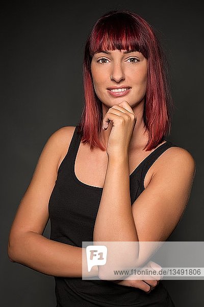 Young woman with red hair  posing  looking into the camera