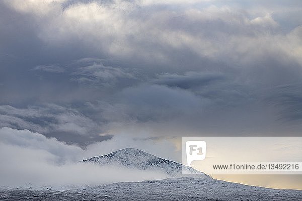 Schneebedeckter Berggipfel mit Wolken in schneebedeckter Landschaft  Sligachan  Portree  Isle of Sky  Schottland  Vereinigtes Königreich  Europa
