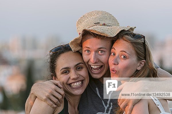 Zwei junge Frauen und ein junger Mann schauen fröhlich in die Kamera  Freunde  Plaza de la Encarnacion  Sevilla  Andalusien  Spanien  Europa
