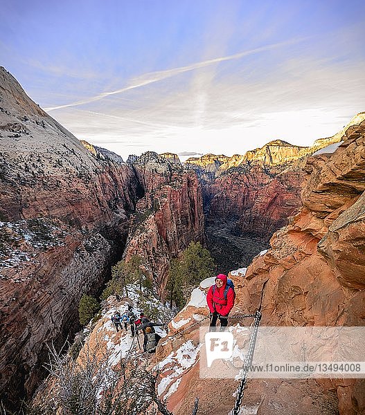 Young woman hikes on the via ferrata descending from Angels Landing  Angels Landing Trail  in winter  Zion Canyon  Mountain Landscape  Zion National Park  Utah  USA  North America