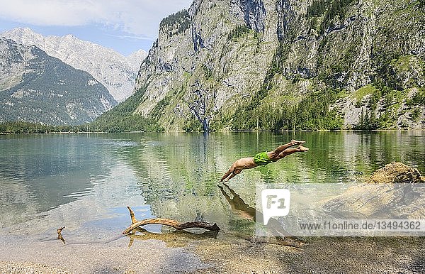 Young man jumps into Lake Obersee  swimming  mountain lake  mountain landscape  in the back Watzmann massif  Salet am Königssee  Berchtesgaden National Park  Berchtesgadener Land  Upper Bavaria  Bavaria  Germany  Europe