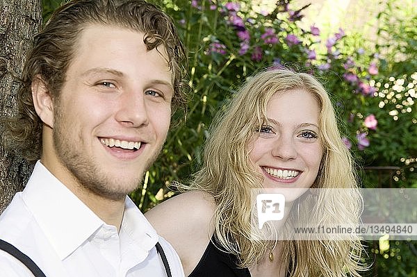 A young couple sitting in the garden  direct look  Germany  Europe