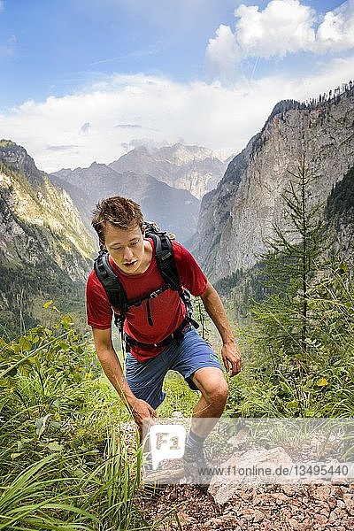Young man climbing  hiking  view from the Rothsteig to the Obersee  KÃ¶nigsee  Alps  mountain landscape  Berchtesgaden National Park  Berchtesgadener Land  Upper Bavaria  Bavaria  Germany  Europe