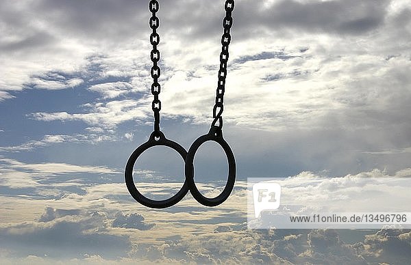 Gymnastic-rings in front of clouds