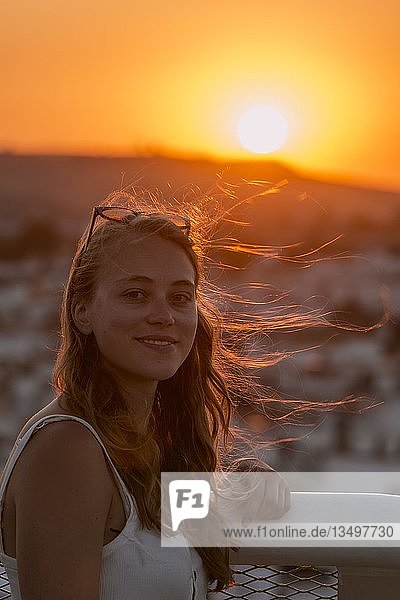 Junge Frau mit weißem Top lächelt Portrait Gegenlicht bei Sonnenuntergang Plaza de la Encarnacion hinten Häuser Sevilla Andalusien Spanien Europa
