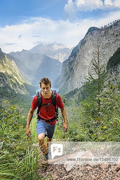 Young man climbing  hiking  view from the Rothsteig to the Obersee  KÃ¶nigsee  Alps  mountain landscape  Berchtesgaden National Park  Berchtesgadener Land  Upper Bavaria  Bavaria  Germany  Europe