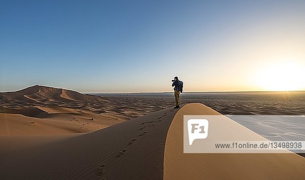 Junger Mann fotografiert  Sanddüne  Sonnenaufgang  Erg Chebbi  Merzouga  Sahara  Marokko  Afrika