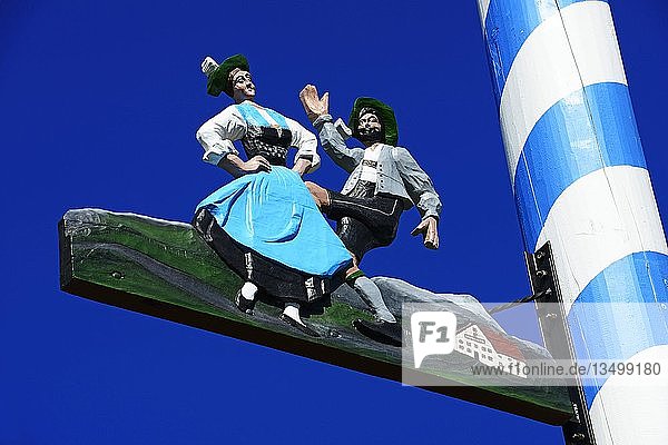 Maibaum mit Zunftzeichen vor blauem Himmel  Volkstänzer  Tengling  Chiemgau  Oberbayern  Bayern  Deutschland  Europa