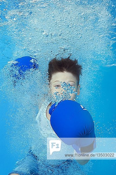 Ein Junge mit Boxhandschuhen posiert unter Wasser im Pool  Ukraine  Europa
