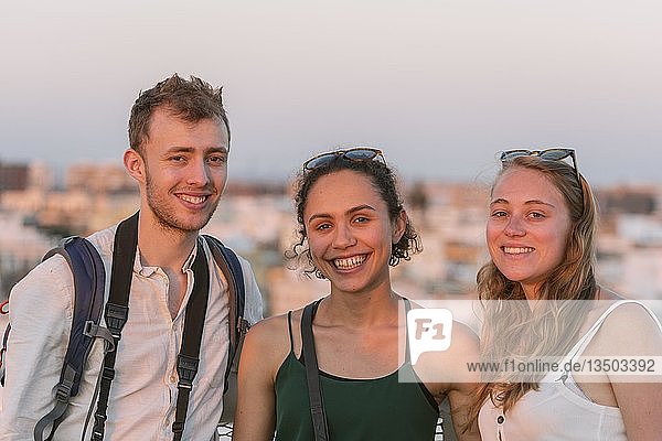 Two young women and young man looking into the camera  friends  Plaza de la Encarnacion  Sevilla  Andalusia  Spain  Europe