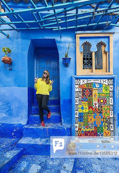 Junge Frau vor einem Haus Blaue Hauswände Medina von Chefchaouen Chaouen Tanger-Tétouan Marokko Afrika