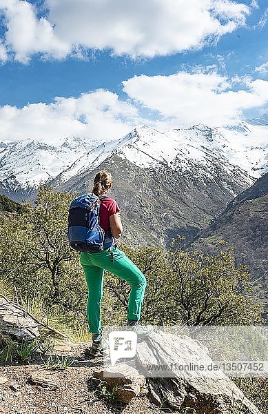 Hiker looks into the distance  behind Sierra Nevada  snowy mountains at Granada  Andalusia  Spain  Europe