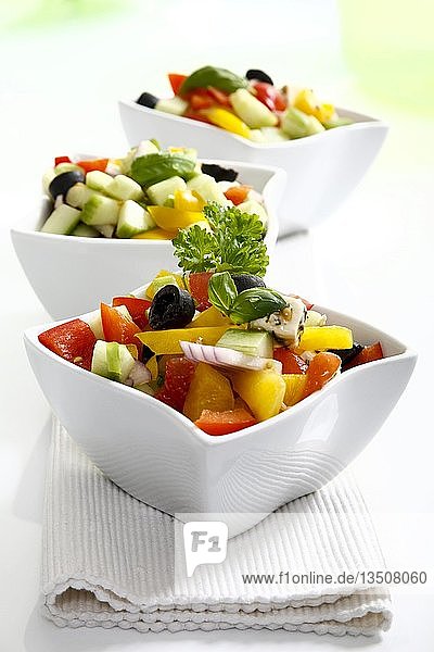 Griechischer Salat mit Zwiebeln  Tomaten  Paprika  Feta und Oliven in kleinen Schälchen
