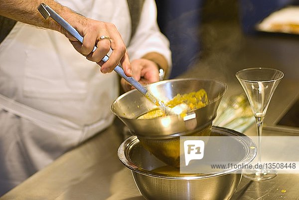Cooking lesson  making spiced oranges  orange syrup being strained through a sieve  Germany  Europe