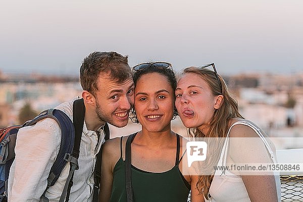Zwei junge Frauen und ein junger Mann schauen in die Kamera  machen Gesichter  Freunde  Plaza de la Encarnacion  Sevilla  Andalusien  Spanien  Europa