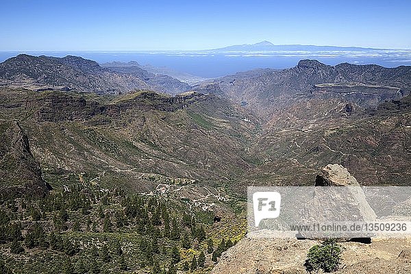 Blick vom Roque Nublo  Kultfelsen der Kanaren  in den Barranco del Chorrillo und die Berge im Westen von Gran Canaria  hinter Teneriffa mit Vulkan Teide  rechts Altavista  Gran Canaria  Kanarische Inseln  Spanien  Europa