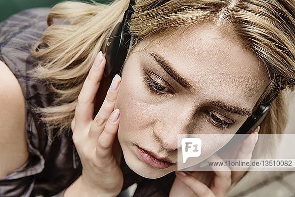 Junge Frau  Teenager hört konzentriert Musik mit Kopfhörern  Nordrhein-Westfalen  Deutschland  Europa