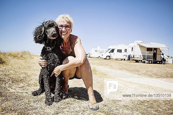Frau umarmt ihren Hund  Königspudel  auf einem Campingplatz  Portbail  Normandie  Frankreich  Europa