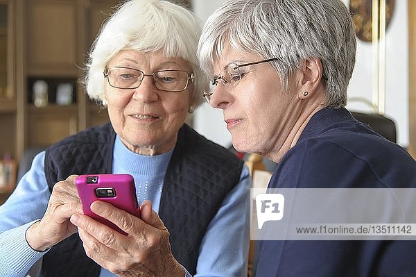Zwei ältere Frauen mit einem Smartphone  Grevenbroich  Nordrhein-Westfalen  Deutschland  Europa