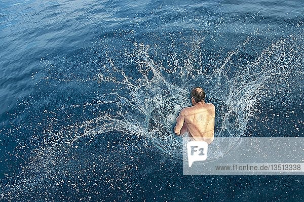 Mann  der eine Kanonenkugel ins Wasser schießt  spritzendes Wasser  Adria  Dalmatien  Kroatien  Europa