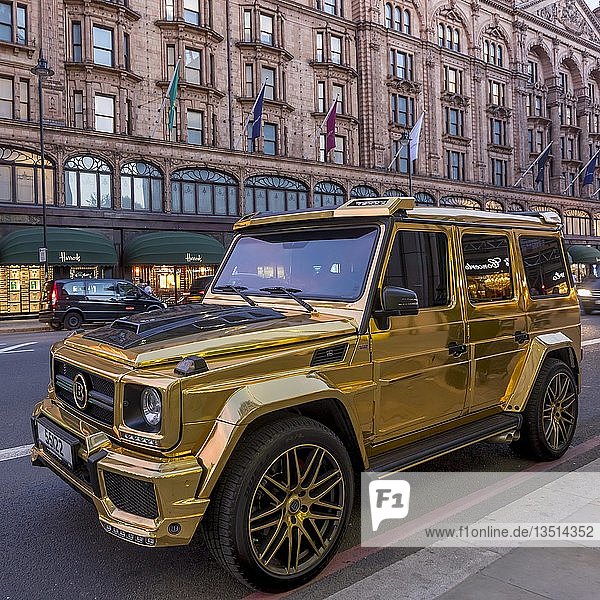 Luxusauto in goldfarbener Lackierung Mercedes Benz W463 G-Klasse Brabus G850 6.0 Widestar parkt vor Kaufhaus Harrods Kensington London Großbritannien Europa