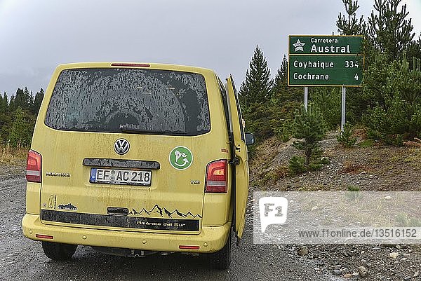 Yellow travel minibus on the Carretera Austral at Cochrane at road sign Patagonia Chile South America