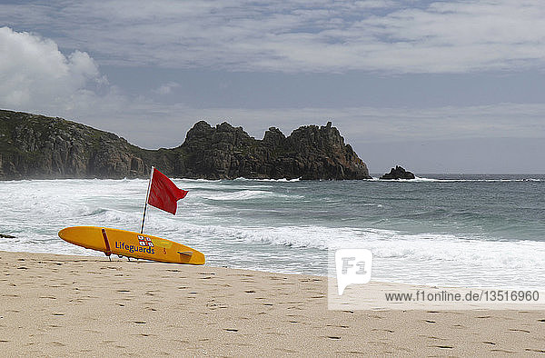 Rote Flagge am Strand von Porthcurno  Porthcurno  St. Levan  Cornwall  England  Vereinigtes Königreich  Europa