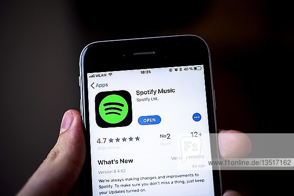 Hand hält iPhone  Spotify Music App im Apple App Store  Musik-Streaming-Dienst  App-Symbol  iPhone  iOS  Smartphone  Display  Deutschland  Europa