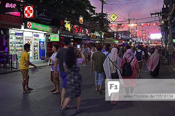 Tourists between bars  shops and restaurants on Bangla Road at dusk  party district and red light district  Patong Beach  Phuket  Thailand  Asia