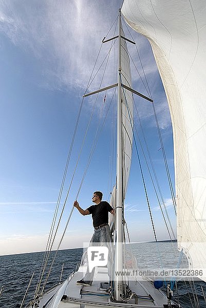 Skipper steht an Deck seiner Yacht